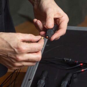 Makro Aufnahme, Tontechnik Aufbau, zwei Hände verbinden Kabel und Mikrofon