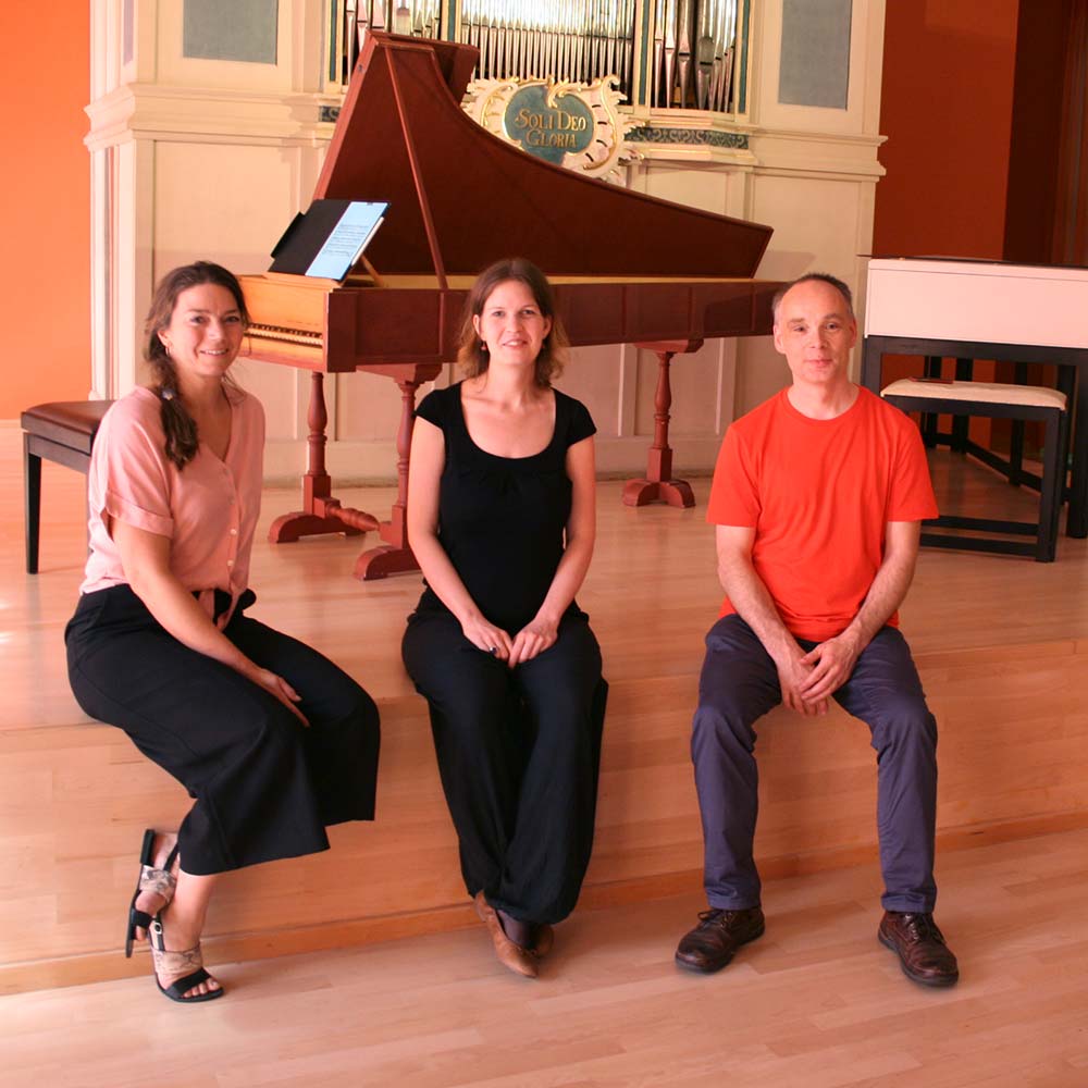 Gruppenfoto, 3 Personen, Klavier im Hintergrund, 3 Musiker,